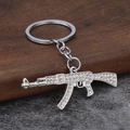 Hip hop AK-47 keychain pendant with sparkling white rhinestones on silver metal - Silver