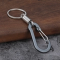 Rugged gunmetal and silver carabiner keychain with spring coil on wood background - Gun Black Square Style