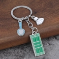 Detail of badminton keychain set with blue racket, white shuttlecock and green court charms - Badminton