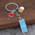 Detail of table tennis keychain with colorful paddles, ball and blue table charms - Table Tennis