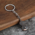 Detailed close-up of a vintage bronze violin keychain on a rustic wooden surface - Antique Red