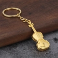 Dettaglio macro di un portachiavi a forma di violino dorato con finitura metallica - Oro