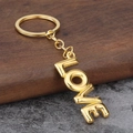 Portachiavi con ciondolo LOVE 3D dorato su sfondo rustico in legno e pietra per San Valentino - Stile Palloncino LOVE (Oro) / Oro