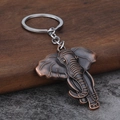 Vintage elephant alloy keychain with bronze finish and detailed texture on stone surface - Antique Red