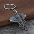 Vintage silver elephant head keychain in alloy metal with detailed trunk carving - Antique Pewter