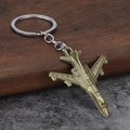 Portachiavi in metallo a forma di aereo da caccia bronzo vintage su fondo legno - Bronzo
