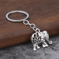 Dettaglio di un portachiavi a forma di elefante argento con trama a spirale su legno - Oro bianco