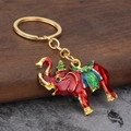Roter Emaille Elefant Schlüsselanhänger mit goldener Krone und Sattel auf Holzgrund - Rot