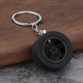 Detailopname van zwarte PVC bandensleutelhanger met profiel en vijf-spaaks lichtmetalen velg - Mat Zwart