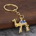 Detailansicht eines goldenen Kamel-Schlüsselanhängers mit blauer und rosa Emaille - Gold Blau