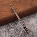 Detail shot of vintage bronze metal snuff spoon with embossed handle on stone surface - Antique Red