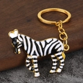 Chic zebra keychain with gold metal frame and black white enamel patterns - Gold