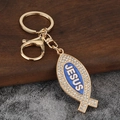 Nahaufnahme von goldenem Jesusfisch-Schlüsselanhänger mit weißen Strasssteinen und Emaille - Gold + Blau