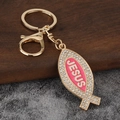 Goldener Fisch-Schlüsselanhänger mit weißen Strasssteinen und Jesus-Text in Pink - Gold + Rosa