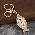 Detail eines Jesus-Fisch-Schlüsselanhängers in Goldlegierung mit Strass und Karabiner - Gold + Weiß