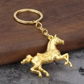 Kreativer goldener Pferde-Schlüsselanhänger mit Metalldetails auf rustikalem Hintergrund - Gold