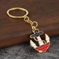 Vintage nautische anker sleutelhanger met kleurrijk email op rustieke hout achtergrond - Goud