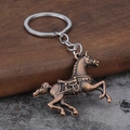 Detailansicht eines Vintage-Pferdeschlüsselanhängers aus Bronze mit Sattelrelief - Antik Rot