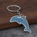 Portachiavi con delfino glitterato blu con bordo argentato su sfondo di legno - Argento