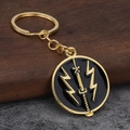 Dettaglio portachiavi metallo bandiera Ucraina con spada smaltata su sfondo di legno - Oro + Nero (Logo Spada Fulmine)
