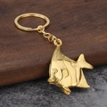 Polierter goldener Engelsfisch-Schlüsselanhänger mit feinen Flossen auf dunklem Holz - Gold