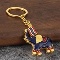 Handcrafted Thai elephant keychain with blue enamel, gold plating, and Thailand flag - Purple