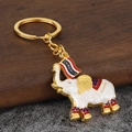 Detail of Thai elephant keychain with white crackle glaze and gold Thailand banner tag - White