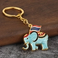 Dettaglio macro del portachiavi a forma di elefante tailandese con smalto blu - Celeste