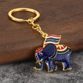 Macro detail of dark blue enamel elephant keychain with Thailand flag and golden ring - Purple