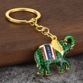 Dettaglio macro del portachiavi a elefante dorato con smalto verde e incisione - Verde