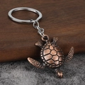 Detailed view of turtle keychain with antique bronze finish and realistic shell texture - Antique Red