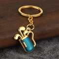 Golden golf bag keychain with 3D clubs and blue honeycomb texture on a stone background - Gold Blue