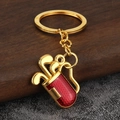 Close-up of golden golf bag keychain with red honeycomb texture and club details - Gold Red
