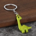 Simpatico portachiavi a dinosauro 3D verde in lega di zinco su sfondo di legno rustico - Verde