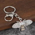 Bienen-Schlüsselanhänger mit Emaille und Kristallen auf Holz- und Steinuntergrund - Weiß K/Silber