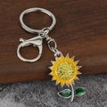 Porte-clés tournesol scintillant avec strass jaunes et émail sur fond en bois sombre - Argenté