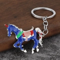 Dettaglio portachiavi a forma di cavallo in smalto blu con sella colorata su legno - Argento e Blu