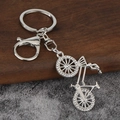 Macro detail of silver alloy bicycle keychain with sparkling rhinestone wheels and lobster clasp - White K White Diamond