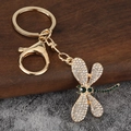 Elegante portachiavi a libellula dorata con cristalli bianchi e verdi su legno - Oro rosa
