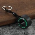Detailed macro view of a creative black PVC tire keychain with green Win Power branding - Fist Green