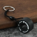 Detailed close-up of a creative PVC tire keychain with braided lanyard and metal ring - Rampage Fist White