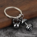 Close-up of metal fitness keychain featuring realistic 24KG kettlebell and dumbbell - Gunmetal