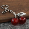 Detail von rotem Kirsch-Schlüsselanhänger mit Glitzer und Silber-Blattanhänger - Silber Rot