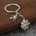 Detailed view of vintage silver spider and web pendants on a metal keychain set - Silver
