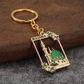 Detail of golden metal keychain with green Medina mosque dome and engraved Madina text - Green