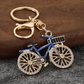 Detail of vintage bicycle keychain with blue frame and sparkling rhinestones on wheels - Gold Base Blue Frame