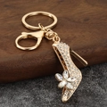 Sparkling gold high heel keychain with white rhinestones and crystal flower on wood - White