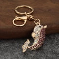 Détail du porte-clés dauphin avec strass violets et fermoir mousqueton doré brillant - Violet