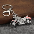 Macro detail of motorcycle keychain with sparkling rhinestones and pink enamel finish - Silver + Pink