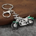 Macro shot of silver motorcycle keychain featuring sparkling rhinestones and green enamel details - White Gold Plated Green